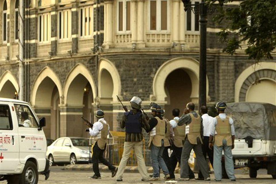 Armed security personnel wait outside the Taj Mahal hotel in Mumbai, India, Thursday, Nov. 27, 2008. Black-clad Indian commandoes raided two luxury hotels to try to free hostages Thursday, and explosions and gunshots shook India's financial capital a day after suspected Muslim militants killed people. (AP Photo/Gurinder Osan)