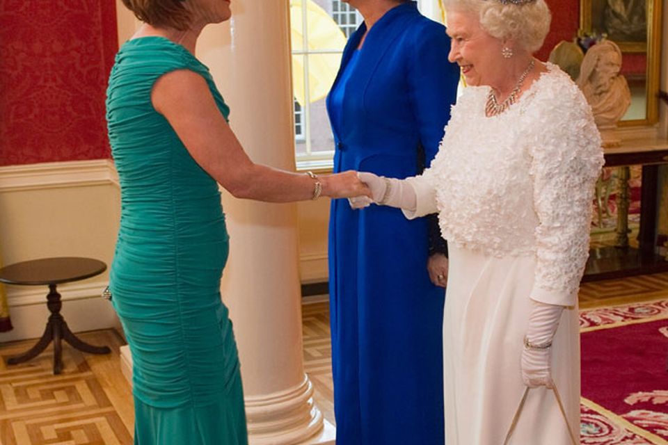 Queen Elizabeth II (R) greets Iris Robinson, the wife of Northern Ireland First Minister Peter Robinson with Irish President Mary McAleese (C) at the State Banquet in Dublin Castle on May 18, 2011 i