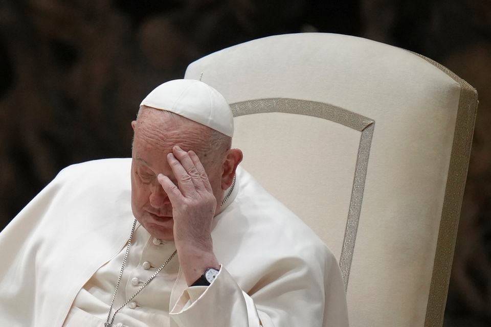 Pope Francis touches his forehead during his weekly general audience at the Vatican on Wednesday (Alessandra Tarantino/AP)