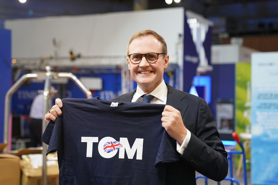 Tom Tugendhat looking at one of his T-shirts during the Conservative Party Conference (Stefan Rousseau/PA)