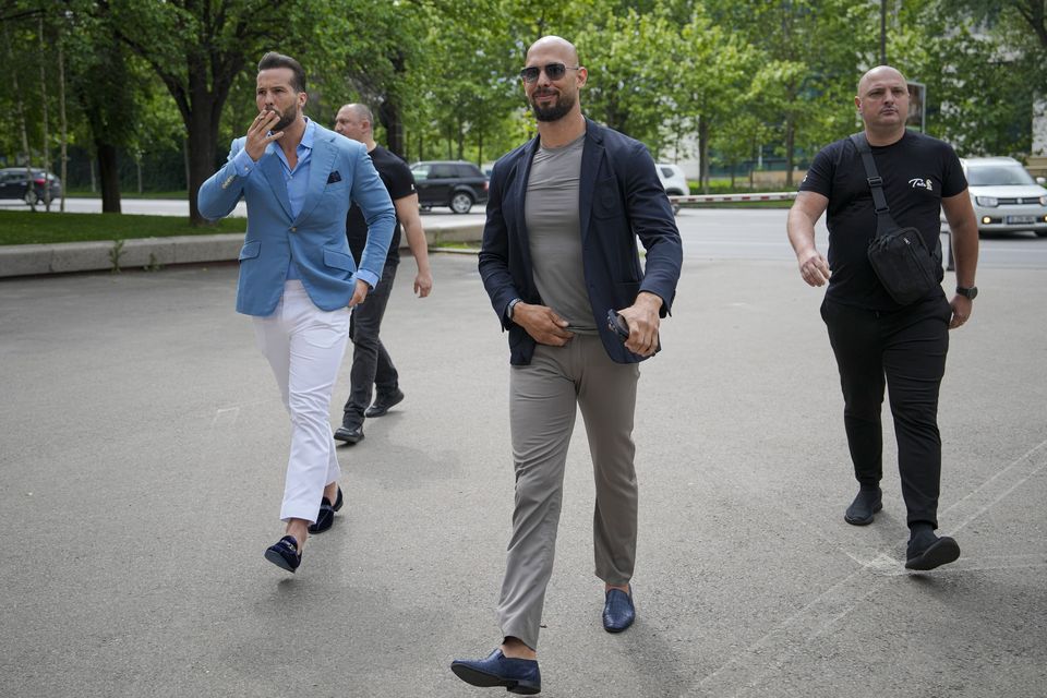 Andrew Tate, centre, and his brother Tristan, left, arrive at the Bucharest Tribunal on Wednesday (Vadim Ghirda/AP)