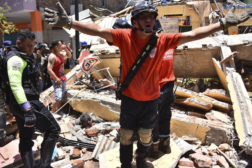 A rescuer worker shouts from the debris of a home that collapsed in the quake (Jorge Sanchez/AP)