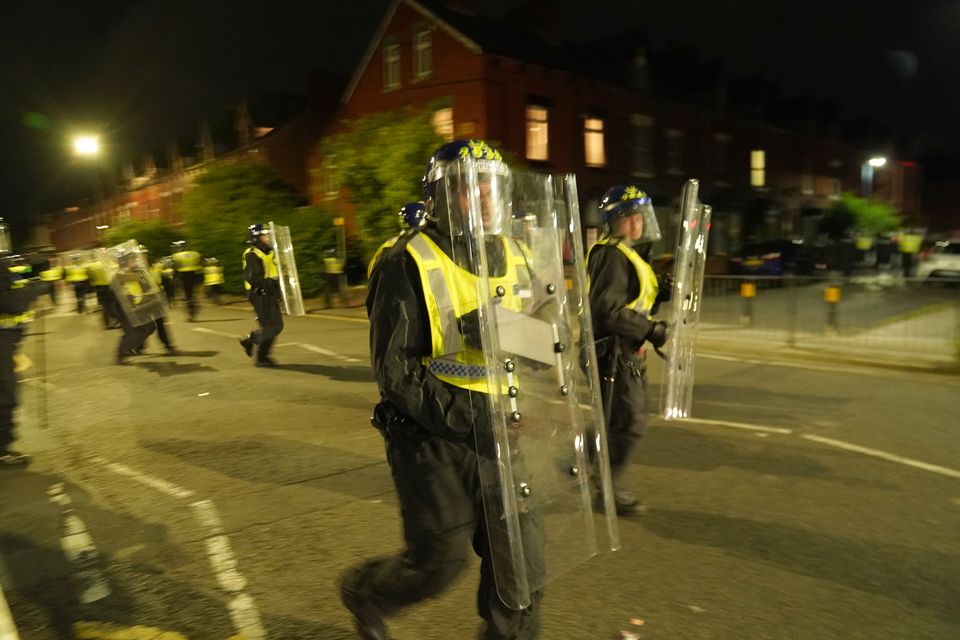 Videos on social media show a crowd of people in a street, with one showing a youth throwing objects at a line of police in riot gear holding shields (Owen Humphreys/PA)