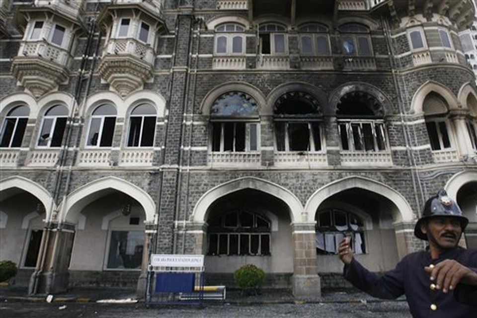 A fireman gestures outside Taj Mahal hotel in Mumbai, India, Saturday, Nov. 29, 2008. Indian commandos killed the last remaining gunmen holed up at the luxury Mumbai hotel Saturday, ending a 60-hour rampage through India's financial capital by suspected Islamic militants that killed people and rocked the nation. (AP Photo/Gautam Singh)