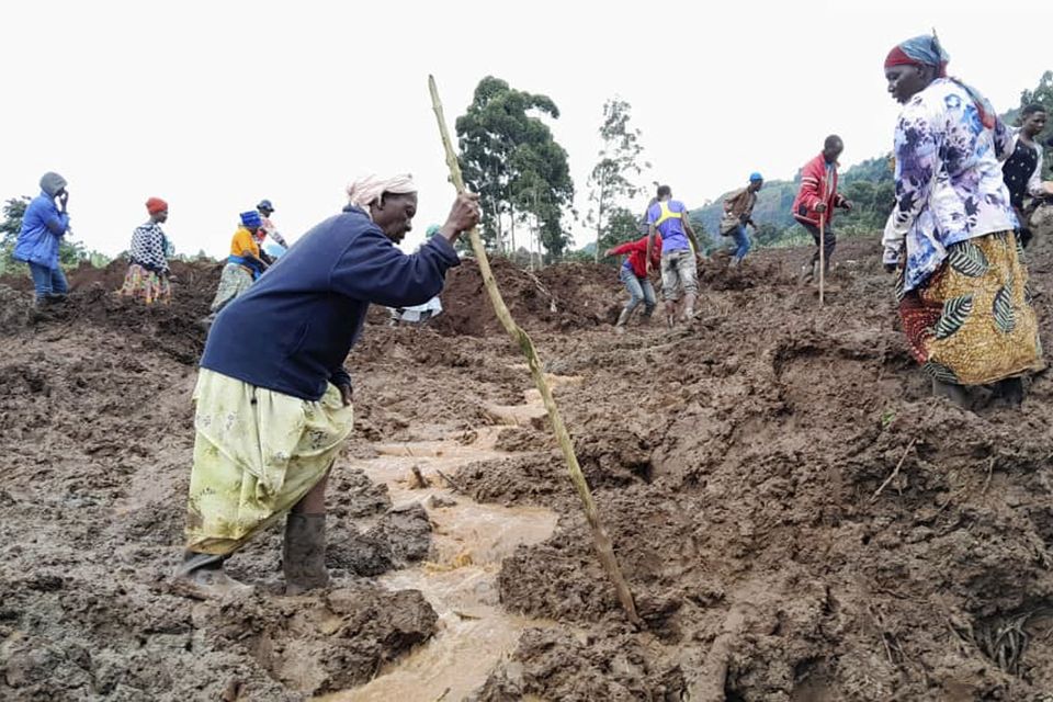 Rescue workers and people search for bodies after landslides following heavy rains buried 40 homes in the mountainous district of Bulambuli, eastern Uganda (Jean Watala/AP)