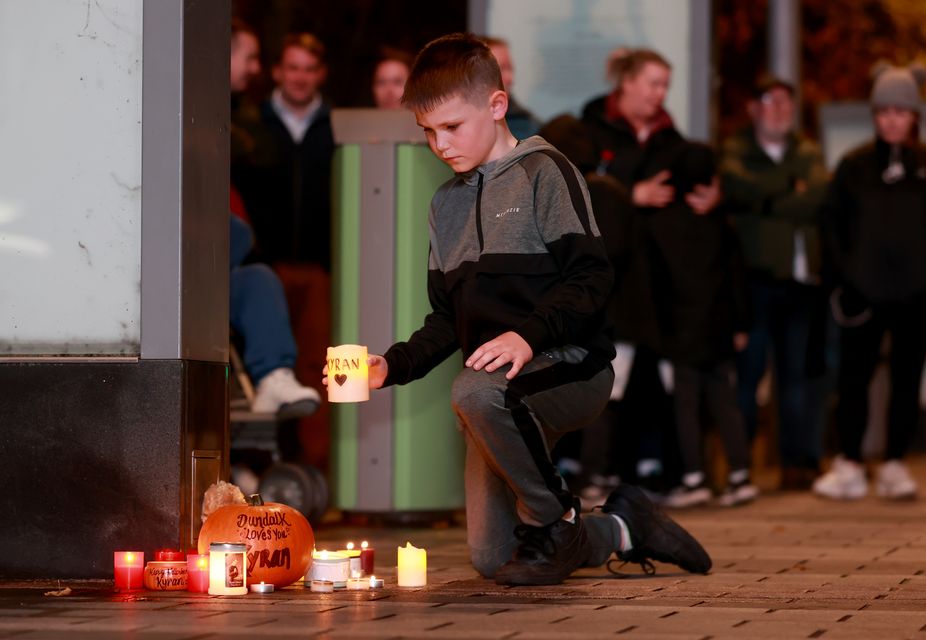 Jay Martin, eight, places a candle among other tributes at a vigil for Kyran Durnin (Liam McBurney/PA)