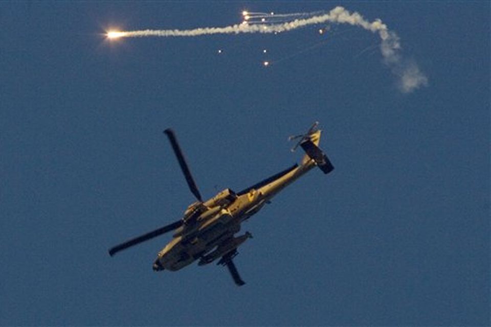 An Israeli attack helicopter fires a flare as seen from the border between Israel and the Gaza Strip, Monday Jan. 5, 2009. Israeli forces pounded Gaza Strip houses, mosques and tunnels Monday from the air, land and sea, killing at least seven children and six other civilians, as they consolidated a bruising offensive against Palestinian militants. (AP Photo/Ariel Schalit)
