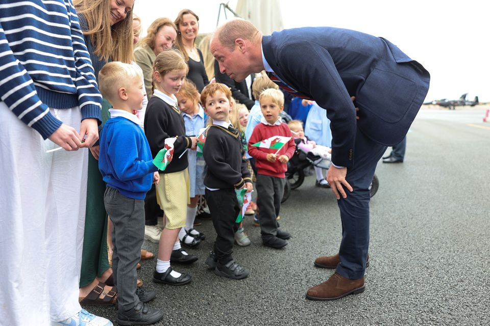 The Prince of Wales talks to a young fan at RAF Valley on Anglesey in July after taking on the role of Royal Honorary Air Commodore from his father, the King. William was stationed at the air base as a search and rescue pilot from 2010 to 2013 (Chris Jackson/PA)