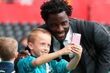 thumbnail: The beautiful game - football fans from around the world -  Swansea City's Wilfried Bony takes a picture with a young fan prior to the Premier League match at the Liberty Stadium, Swansea.