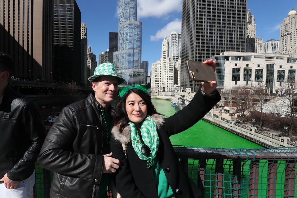 A couple take a selfie as the Chicago River is turned green for St Patrick’s Day (Brian Lawless/PA)