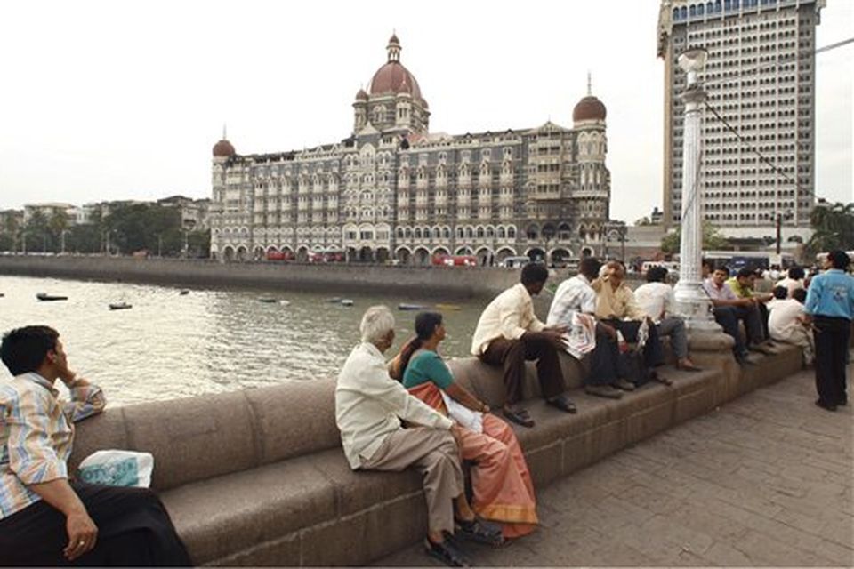 People look at the Taj Mahal hotel, where Indian commandos had a severe operation against terrorists, in Mumbai, India, Saturday, Nov. 29, 2008. Indian commandos killed the last remaining gunmen holed up at a luxury Mumbai hotel Saturday, ending a 60-hour rampage through India's financial capital by suspected Islamic militants that killed people and rocked the nation. (AP Photo/Saurabh Das)