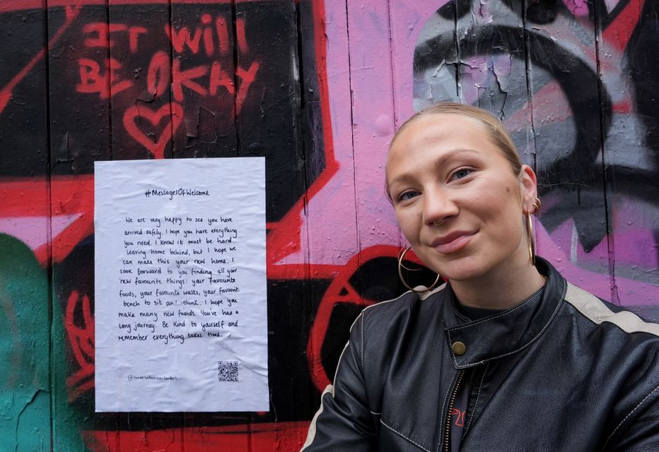 Colette Batten-Turner, CEO of Conversation Over Borders, places posters around the city in Brighton (Gareth Fuller/PA)