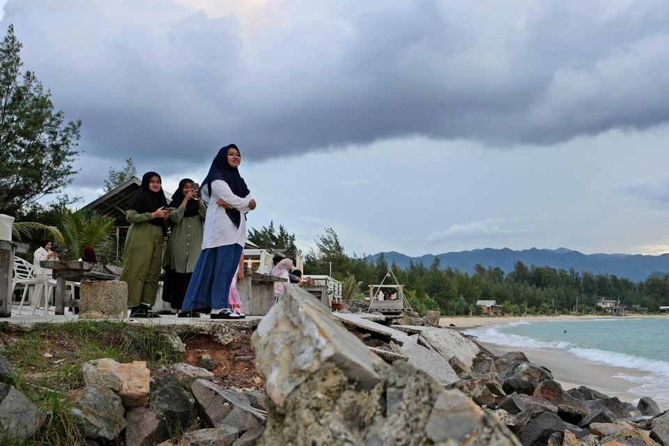 Young girls enjoy the view at Lampuuk beach, one of the areas hardest hit by the Indian Ocean tsunami in 2004 (Achmad Ibrahim/AP)