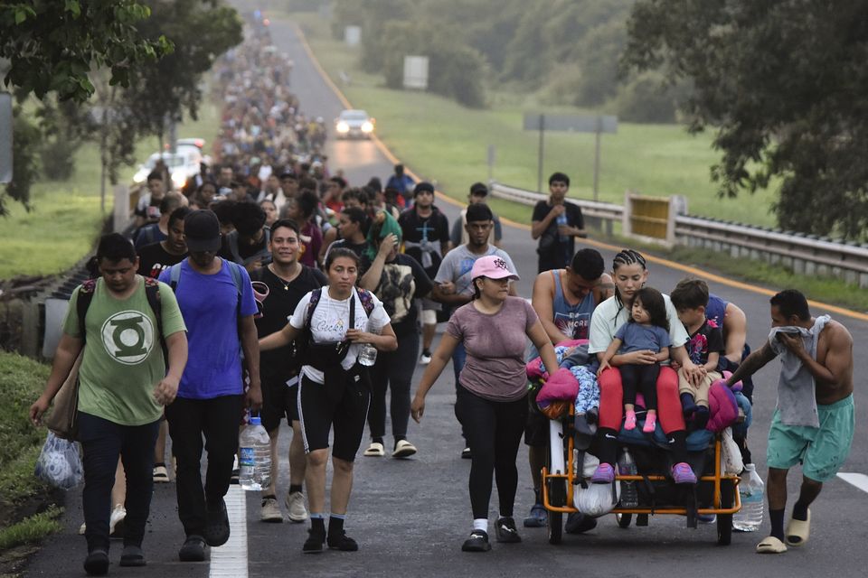 FILE – Migrants walk along the Huixtla highway toward the United States. (Edgar H. Clemente, File/AP)