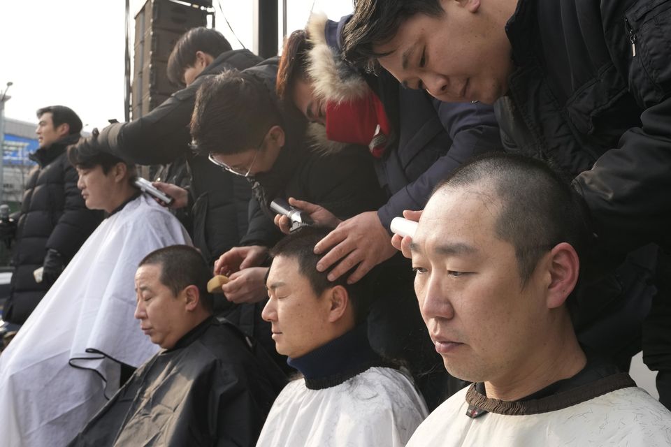 Supporters of impeached South Korean President Yoon Suk Yeol had their heads shaved as they attend a rally to oppose his impeachment near the presidential residence in Seoul (AP)