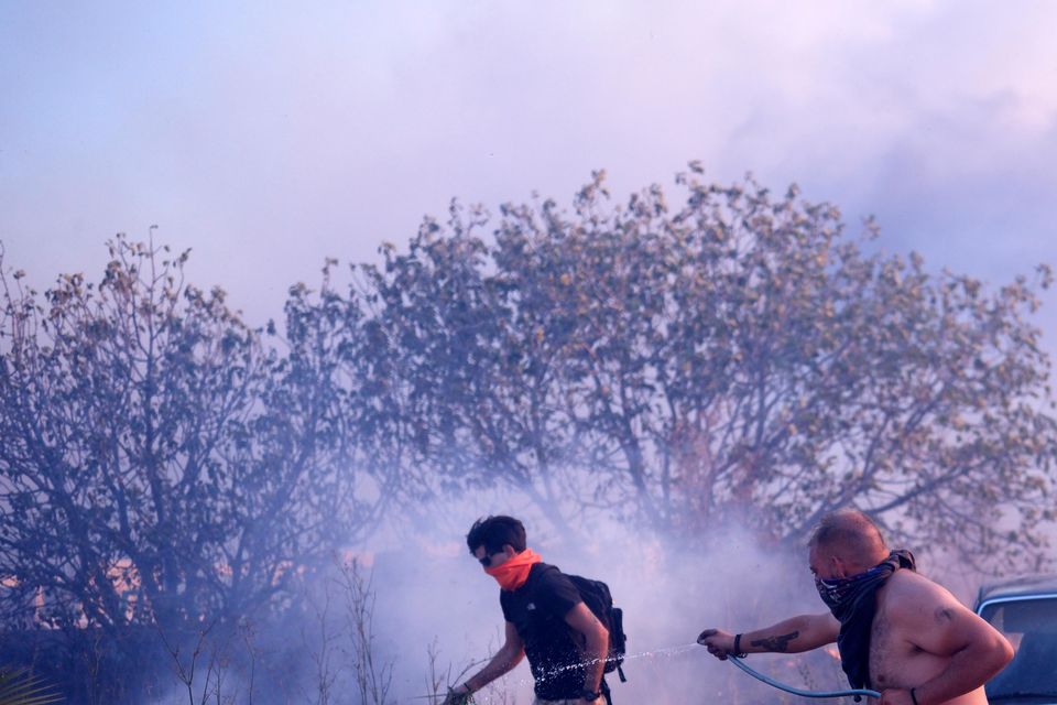 Volunteers worked to extinguish flames near a house in northern Athens (Aggelos Barai/AP)