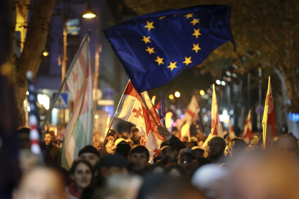 Protesters with Georgian and EU flags take part in the rally in Tbilisi, Georgia, on Monday (Zurab Tsertsvadze/AP)