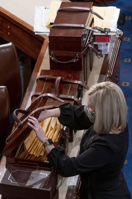 Boxes containing Electoral College votes are opened as a joint session of the House and Senate convenes (Andrew Harnik/AP)