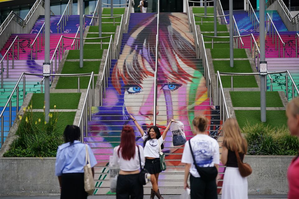 A fan takes a photograph at the Swiftie Steps and murals at Wembley Park, north west London (Yui Mok/PA)