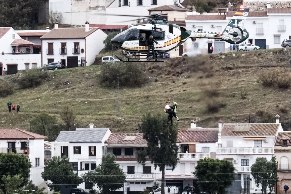 Emergency teams in a Guardia Civil helicopter rescue a person who was stranded in the town of Alora, Malaga (Gregorio Marrero/AP)