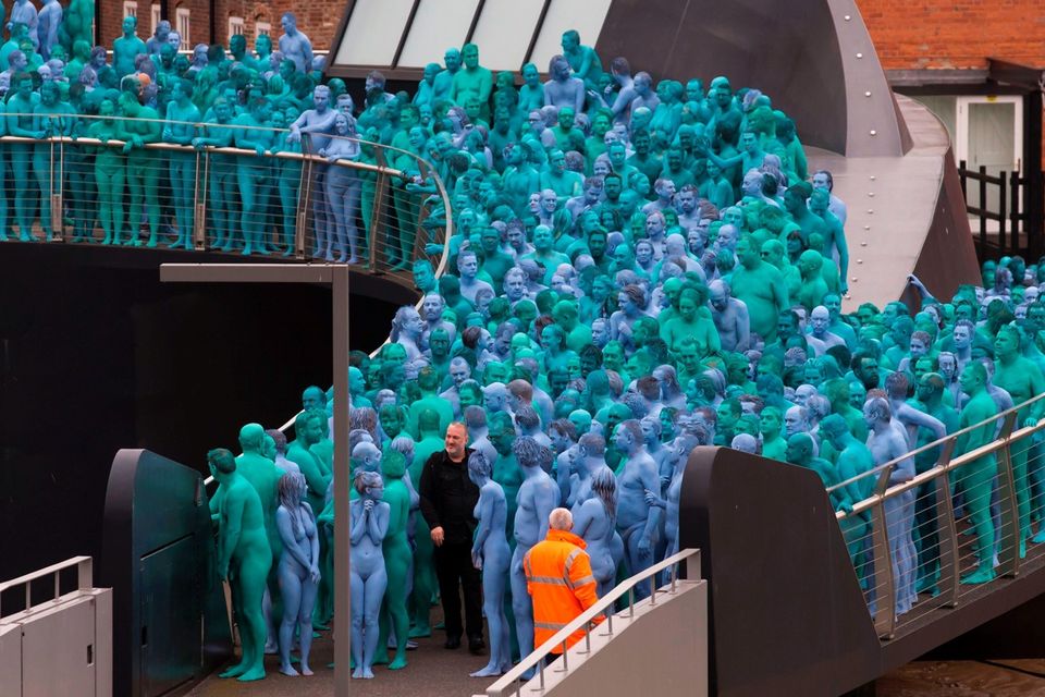 US artist Spencer Tunick, (front row, wearing black) walks between naked volunteers, painted in blue to reflect the colours found in Marine paintings in Hull's Ferens Art Gallery, participate in US artist, Spencer Tunick's "Sea of Hull" installation on the Scale Lane swing bridge in Kingston upon Hull on July 9, 2016. AFP/Getty Images