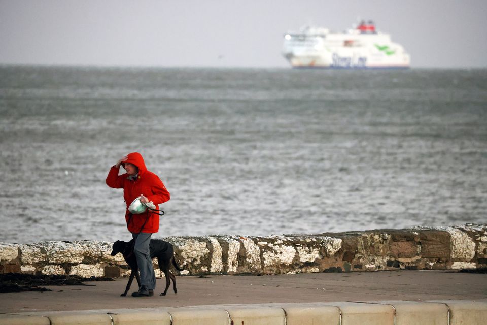 A man struggles in the strong winds as a Stenaline ferry is anchored at the edge of Belfast Lough during Storm Darragh earlier this month (Picture by Peter Morrison)