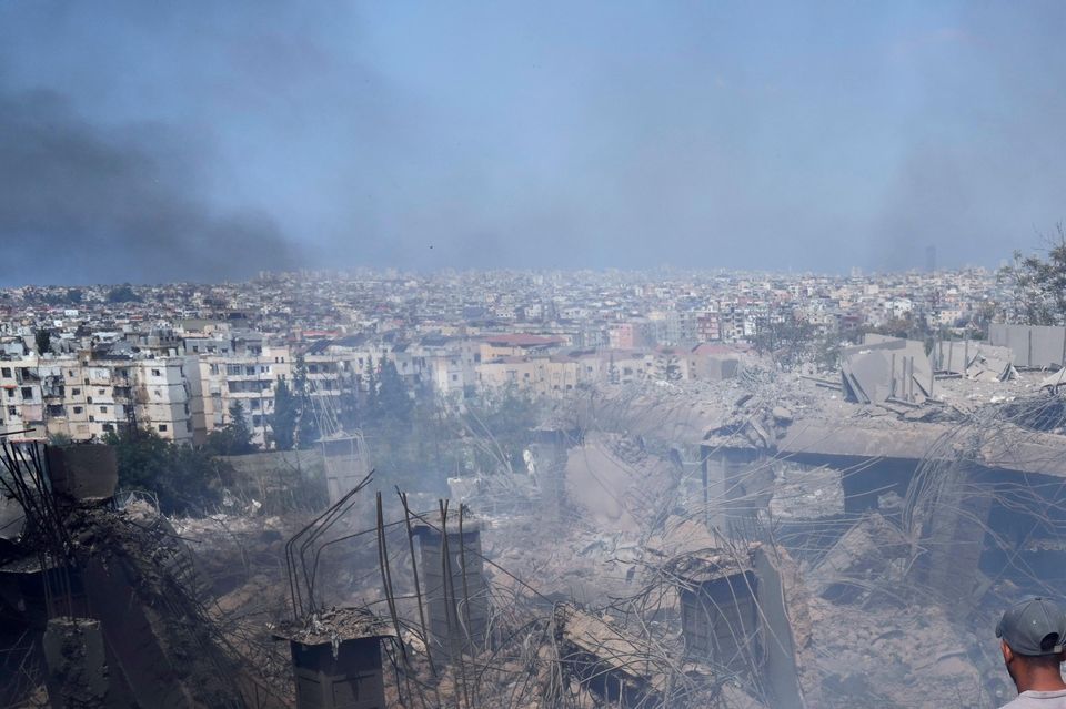 People check a damaged building at the site of an Israeli airstrike in Choueifat, south east of Beirut (Hussein Malla/AP)