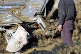 thumbnail: ALTERNATE CROP AND CAPTION ADDITION - A mother strokes the head of her dead daughter as she and her husband look at the body of their daughter they found in a courtesy vehicle of a driving school that's smashed by a tsunami at Yamamoto, northeastern Japan, on Saturday March 12, 2011, a day after a giant earthquake and tsunami struck the country's northeastern coast. (AP Photo/Kyodo News)  JAPAN OUT, MANDATORY CREDIT, NO SALES IN CHINA, HONG  KONG, JAPAN, SOUTH KOREA AND FRANCE