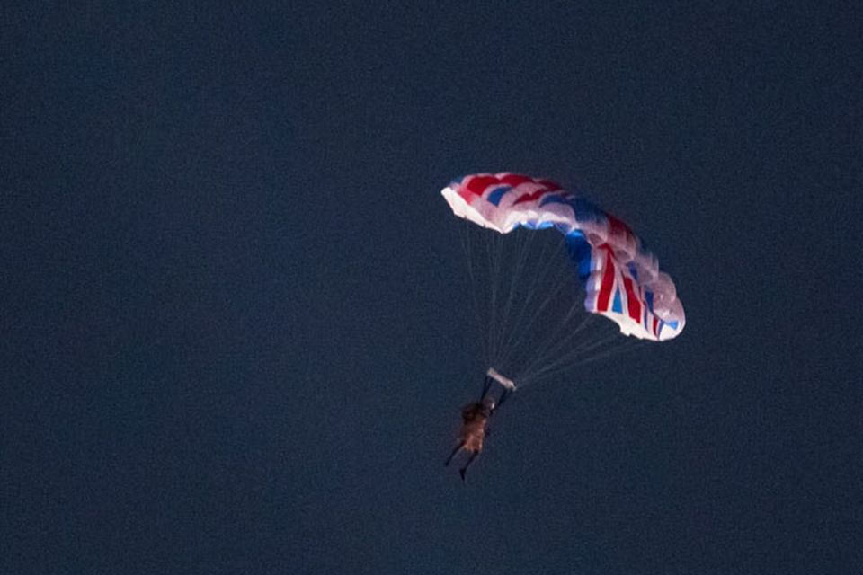 LONDON, ENGLAND - JULY 27:  Performers dressed up as Queen Elizabeth II and James Bond parachute out of a helicopter above the Olympic Stadium during the Opening Ceremony of the London 2012 Olympic Games on July 27, 2012 in London, England. (Photo by Daniel Berehulak/Getty Images)