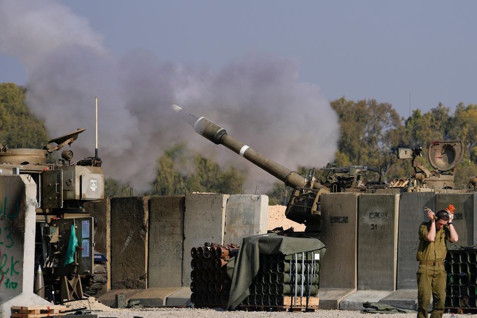 An Israeli soldier covers his ears as an artillery gunner fires into the Gaza Strip from a position in southern Israel on Thursday (Matias Delacroix/AP)