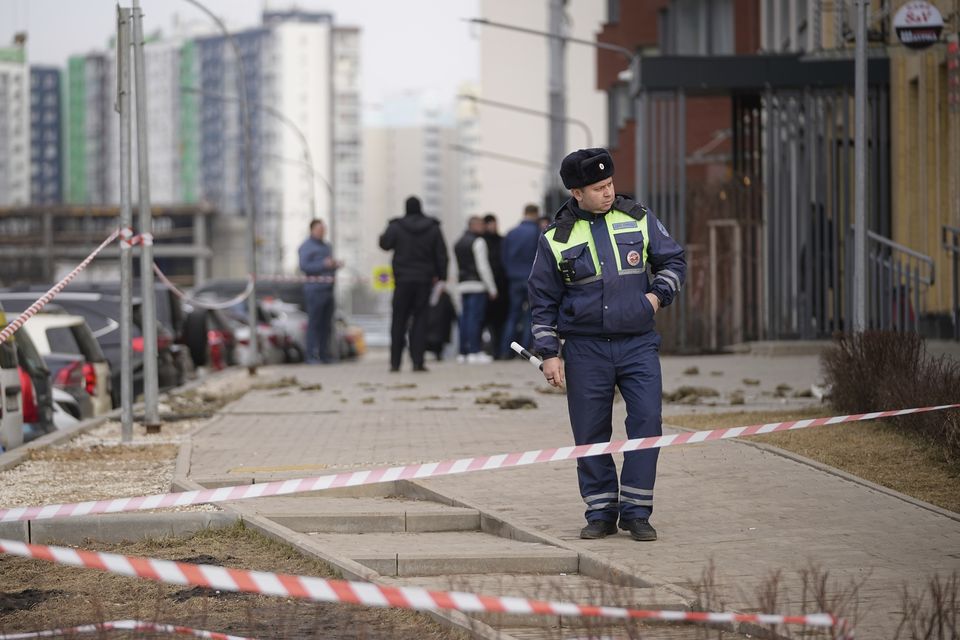 A police officer patrols near an apartment building where a downed Ukrainian drone fell in Sapronovo village, outside Moscow (AP)