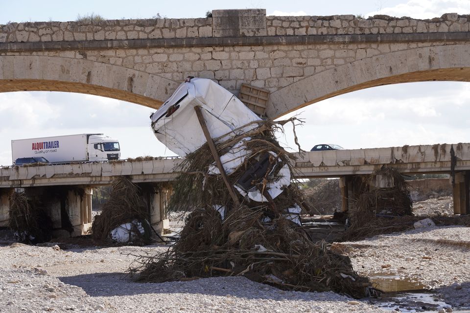 A car sits beneath a bridge after floods on the outskirts of Valencia (Alberto Saiz/AP/PA)