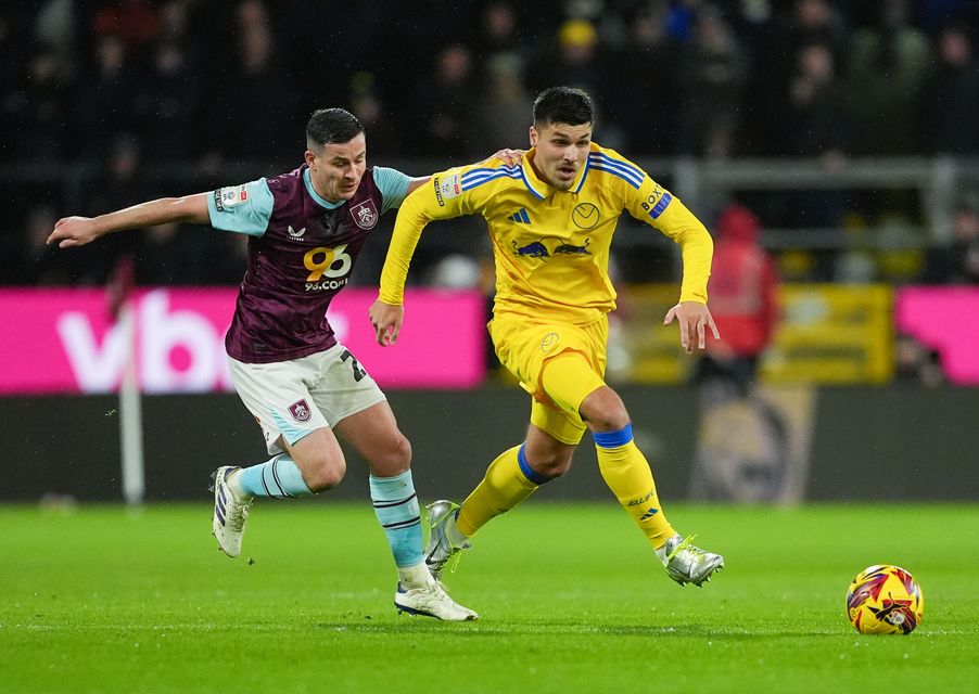 Burnley midfielder Josh Cullen (left) and Leeds forward Joel Piroe battle for the ball at Turf Moor (Martin Rickett/PA)