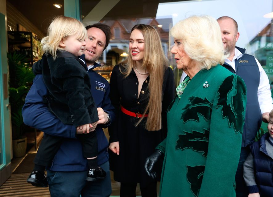 Queen Camilla meets the owner of Knotts Bakery, William Corrie, his wife Zoe Salmon and their son Fitz during a visit to Lisburn Road in Belfast. Image: Liam McBurney/PA Wire