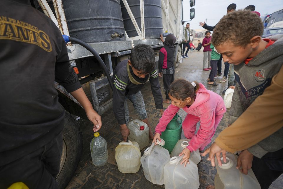 Children collect water from a truck at a tent camp for displaced Palestinians in Deir al-Balah, Gaza Strip (Abdel Kareem Hana/AP)