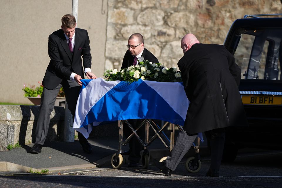 Mr Salmond’s coffin, draped in a Saltire flag, is taken inside the church for his funeral (Andrew Milligan/PA)