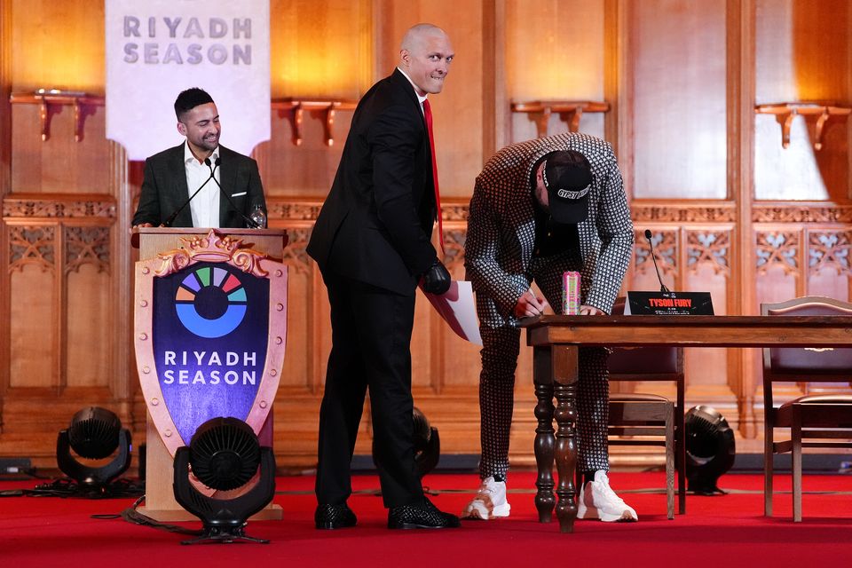 Tyson Fury, right, signed a photo of his previous fight with Oleksandr Usyk (Zac Goodwin/PA)