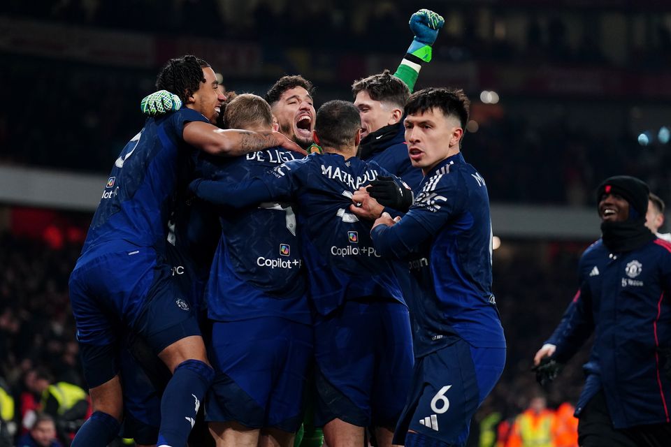 Altay Bayindir is mobbed by Manchester United players after the penalty shootout (Mike Egerton/PA)