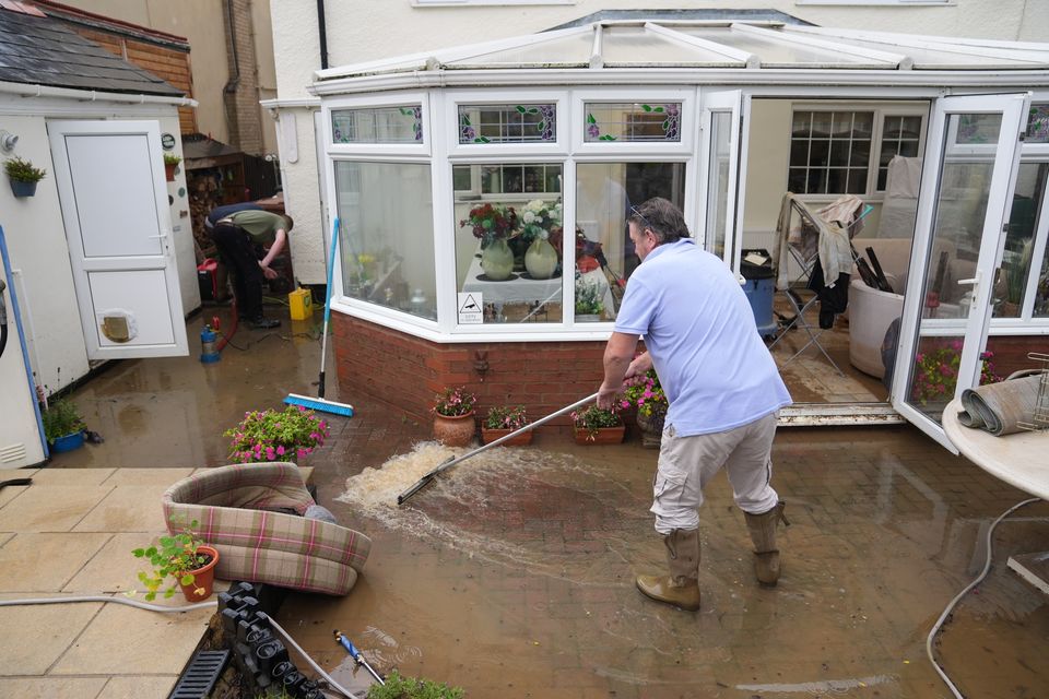 Neighbours help to clear flood water from the home of Jon Sayles in Grendon, Northamptonshire (Joe Giddens/PA)