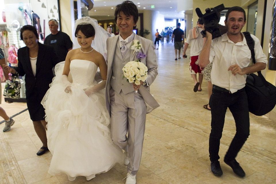 A bride and groom from Japan walk in the lobby of the Sheration Waikiki Hotel, Friday, March 11, 2011 in Honolulu.  A ferocious tsunami unleashed by Japan's biggest recorded earthquake slammed into its eastern coast Friday, killing hundreds of people as it carried away ships, cars and homes, and triggered widespread fires that burned out of control. Hours later, the waves washed ashore on Hawaii and the U.S. West coast, where evacuations were ordered from California to Washington but little damage was reported
