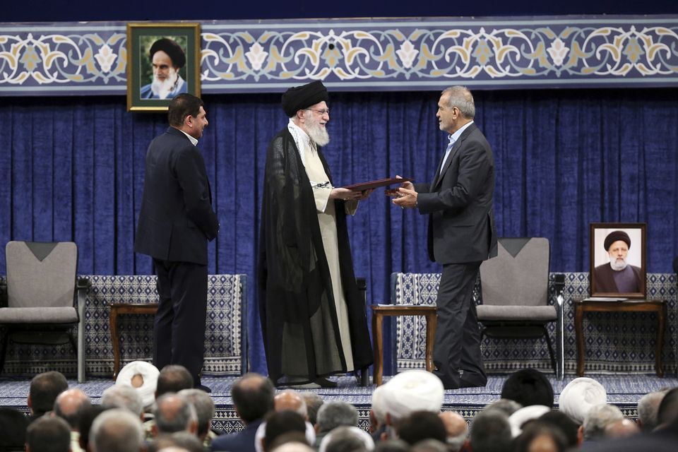 Iran’s Supreme Leader, Ayatollah Ali Khamenei, gives his official seal of approval to President Masoud Pezeshkian, watched by acting president Mohammad Mokhber (left) (Office of the Iranian Supreme Leader/AP)