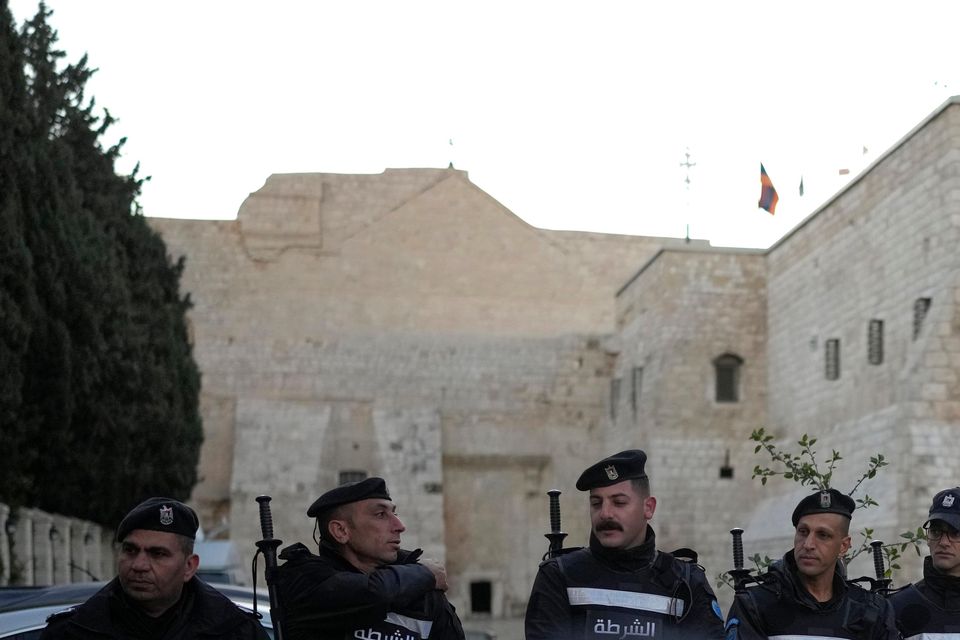 Palestinian police line up next to the Church of the Nativity, traditionally believed to be the birthplace of Jesus, on Christmas Eve, though the usual crowds are not expected (AP Photo/Matias Delacroix)