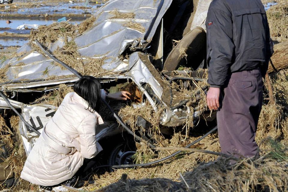ALTERNATE CROP AND CAPTION ADDITION - A mother strokes the head of her dead daughter as she and her husband look at the body of their daughter they found in a courtesy vehicle of a driving school that's smashed by a tsunami at Yamamoto, northeastern Japan, on Saturday March 12, 2011, a day after a giant earthquake and tsunami struck the country's northeastern coast. (AP Photo/Kyodo News)  JAPAN OUT, MANDATORY CREDIT, NO SALES IN CHINA, HONG  KONG, JAPAN, SOUTH KOREA AND FRANCE