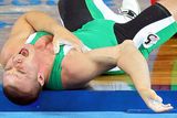 thumbnail: Janos Baranyai of Hungary screams in pain after dropping the weights during the Men's 77kg weightlifting competition event at the University of Aeronautics and Astronautics Gymnasium