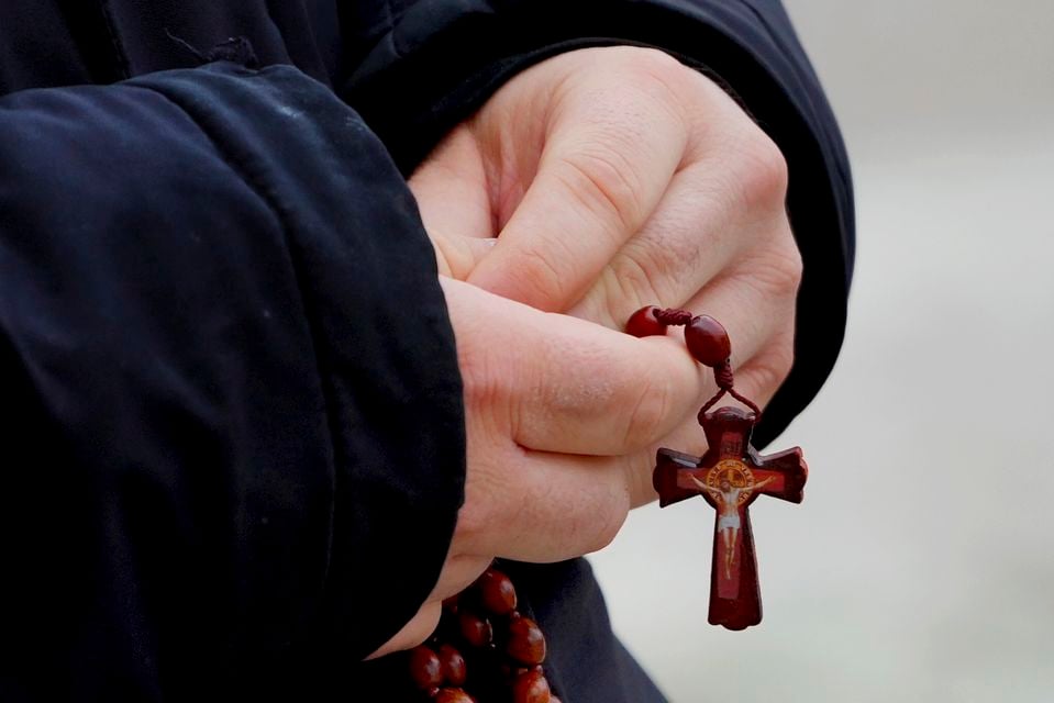 A man holds rosary beads as he prays for Pope Francis (Kirsty Wigglesworth/AP)