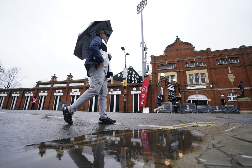 A mans walks past Craven Cottage, London, in wet weather as a new yellow weather warning for rain was issued for southern England (Andrew Matthews/PA)