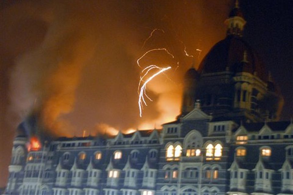 The Taj Hotel, Mumbai's landmark hotel, is caught fire after an attack in Mumbai, India's financial capital, on early Thursday morning November 27, 2008. Teams of heavily armed gunmen stormed luxury hotels, a popular restaurant, hospitals and a crowded train station in coordinated attacks across India's financial capital Wednesday night, killing at least 78 people and taking Westerners hostage, police said. (AP Photo)