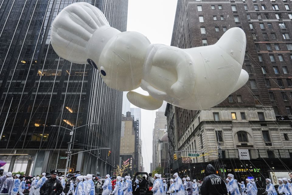 Handlers guide the Pillsbury Doughboy balloon down Sixth Avenue (Julia Demaree Nikhinson/AP)