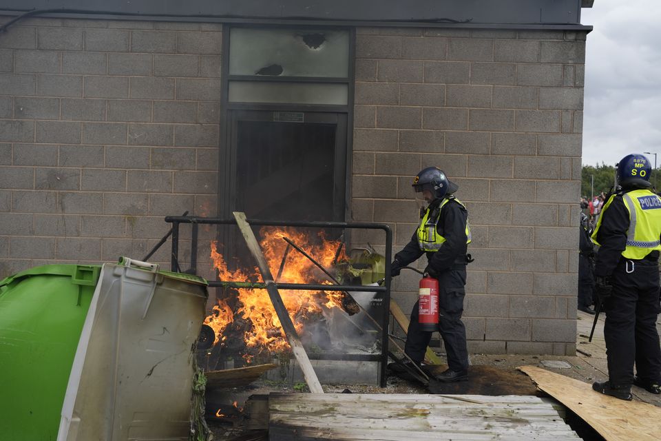 A fire is extinguished by police officers outside the Holiday Inn Express in Rotherham (Danny Lawson/PA)