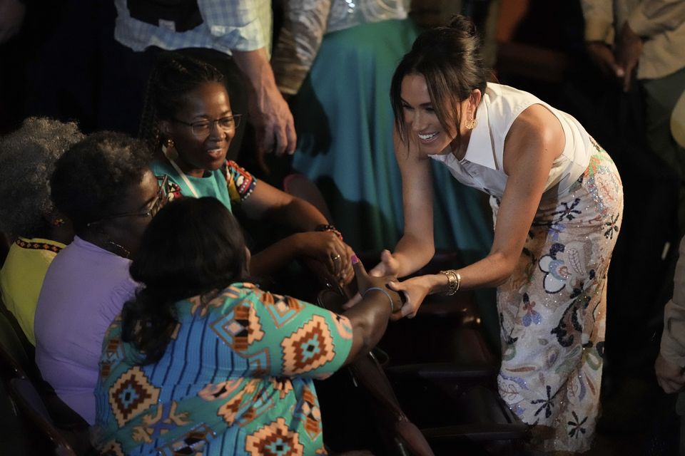 Meghan greets people during a forum. (AP Photo/Ivan Valencia)